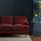 Sofa covered in a red velvet upholstery fabric