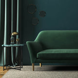 Sofa covered in a green velvet upholstery fabric 