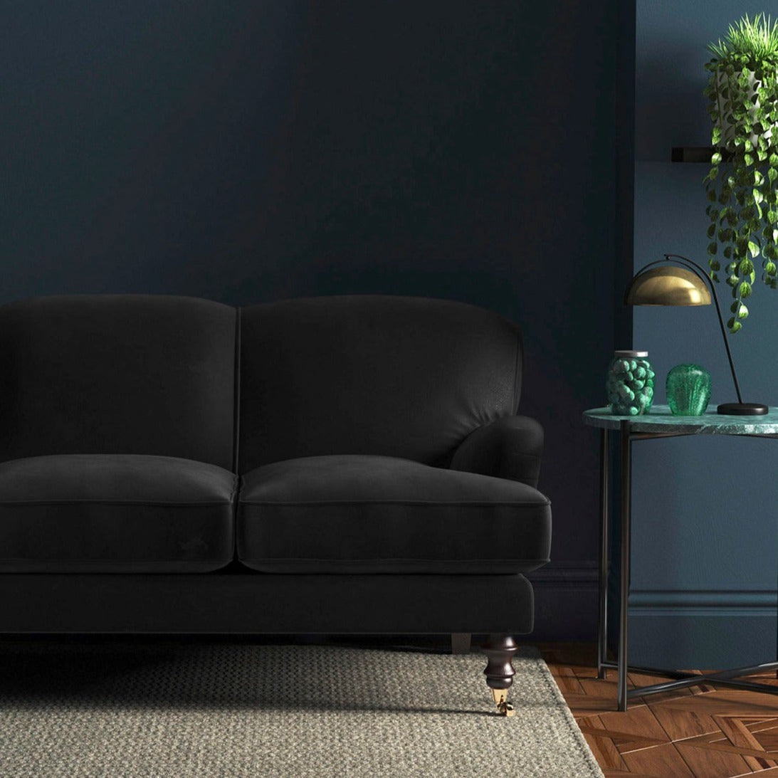 Sofa covered in a black velvet upholstery fabric 