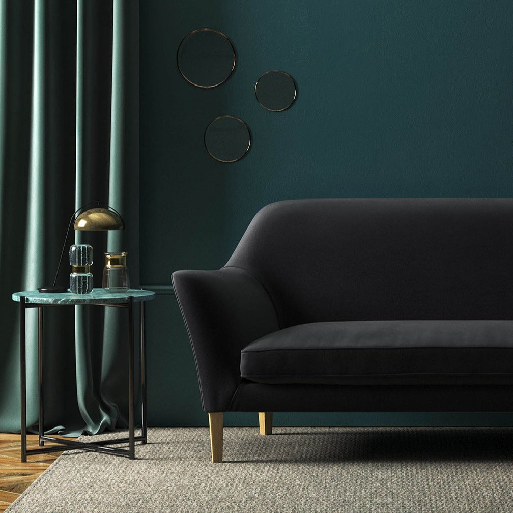 Sofa covered in a black velvet upholstery fabric
