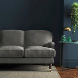 Sofa covered in a grey velvet upholstery fabric