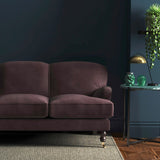 Sofa covered in a purple velvet upholstery fabric