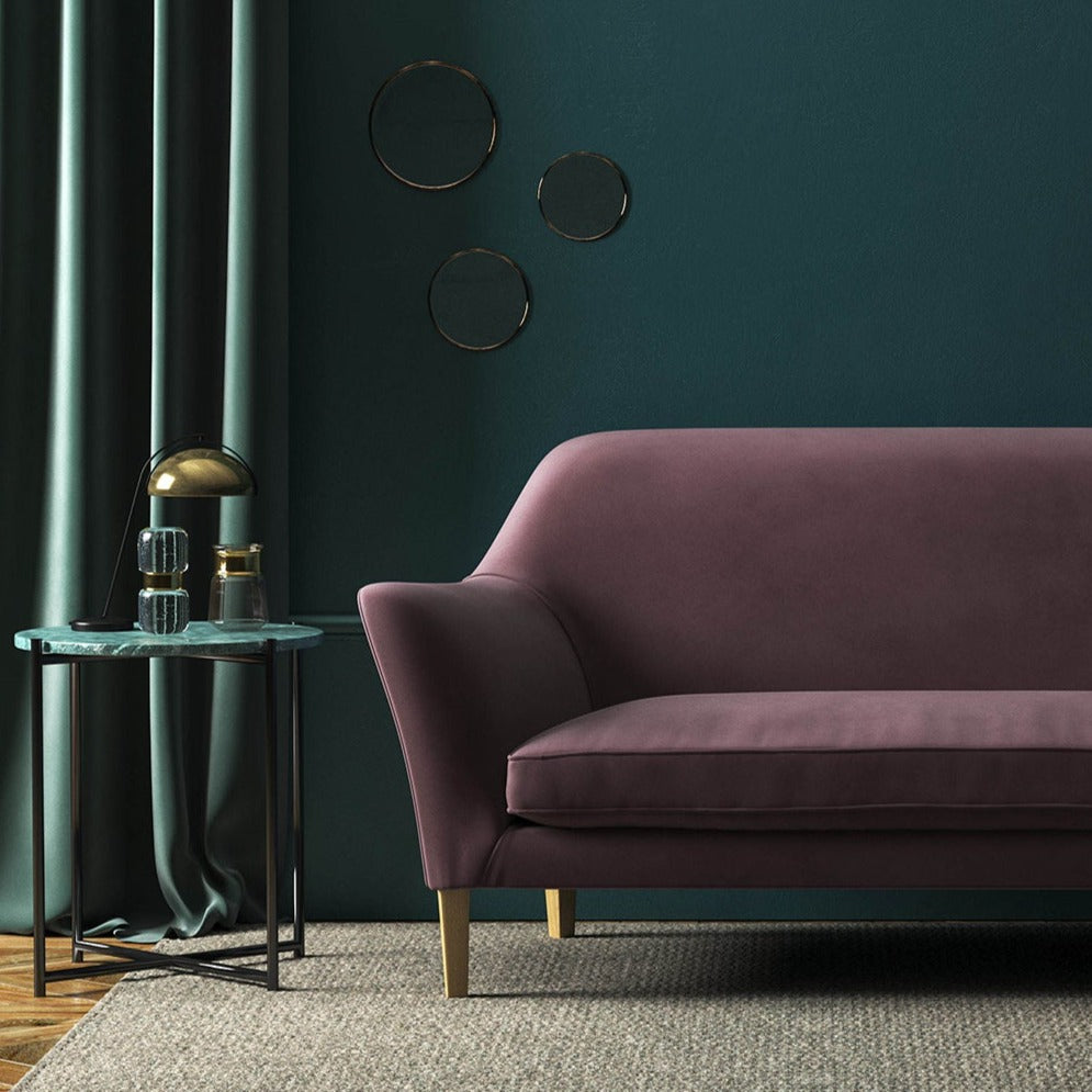 Sofa covered in a purple velvet upholstery fabric 