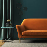 Sofa covered in a orange velvet upholstery fabric 