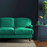 Sofa covered in a green velvet upholstery fabric