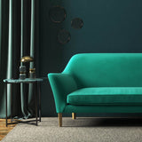 Sofa covered in a green velvet upholstery fabric 