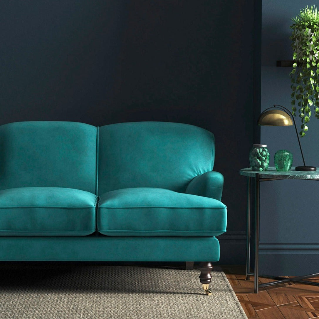 Sofa covered in a blue velvet upholstery fabric