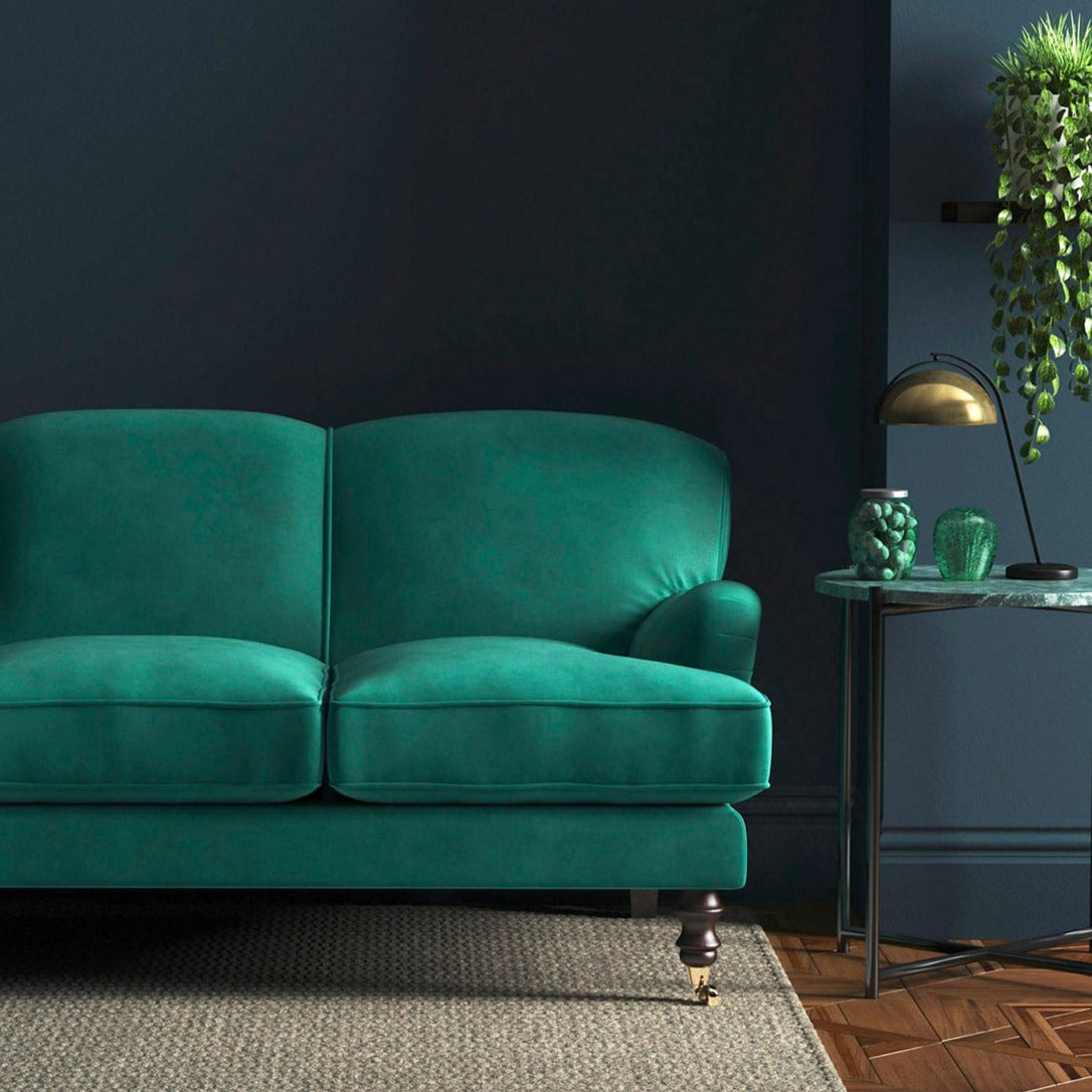 Sofa covered in a blue velvet upholstery fabric