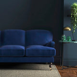 Sofa covered in a blue velvet upholstery fabric