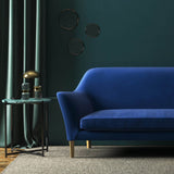Sofa covered in a blue velvet upholstery fabric 