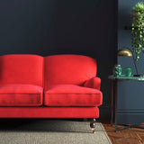Sofa covered in a red velvet upholstery fabric
