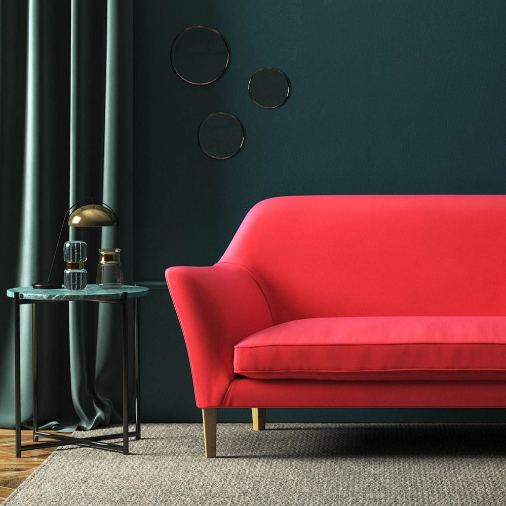 Sofa covered in a red velvet upholstery fabric 