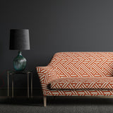 Sofa upholstered in a large scale geometric print with orange and white colours