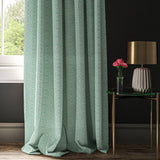 Curtain in a light blue and white wavy geometric weave.