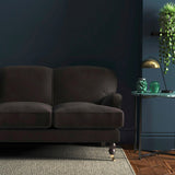 Sofa covered in a brown velvet upholstery fabric