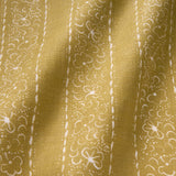 Printed linen fabric sample – a delicate pattern of moons and star-like dots in yellow and cream