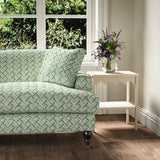 Printed linen fabric - a contemporary lattice design in green, blue, cream and white – on a sofa