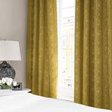Linen curtains with a delicate pattern of moons and star-like dots in yellow and cream