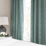 Linen curtains with a delicate pattern of moons and star-like dots in blue and cream