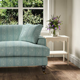 Printed linen fabric – a delicate pattern of moons and star-like dots in blue and cream – on a sofa