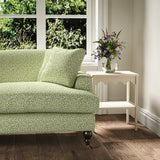 Printed linen fabric – damask-style pattern in green and cream – on a sofa