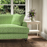 Printed linen fabric – damask-style pattern in green and cream – on a sofa