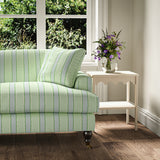 Printed linen fabric – a bold blocks of colour in this inviting stripe are softened with a painterly finish in blue, green and white – on a sofa