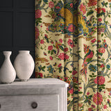 A printed velvet fabric depicts a menagerie of parrots, lions, and alluring flowers in cream as curtains