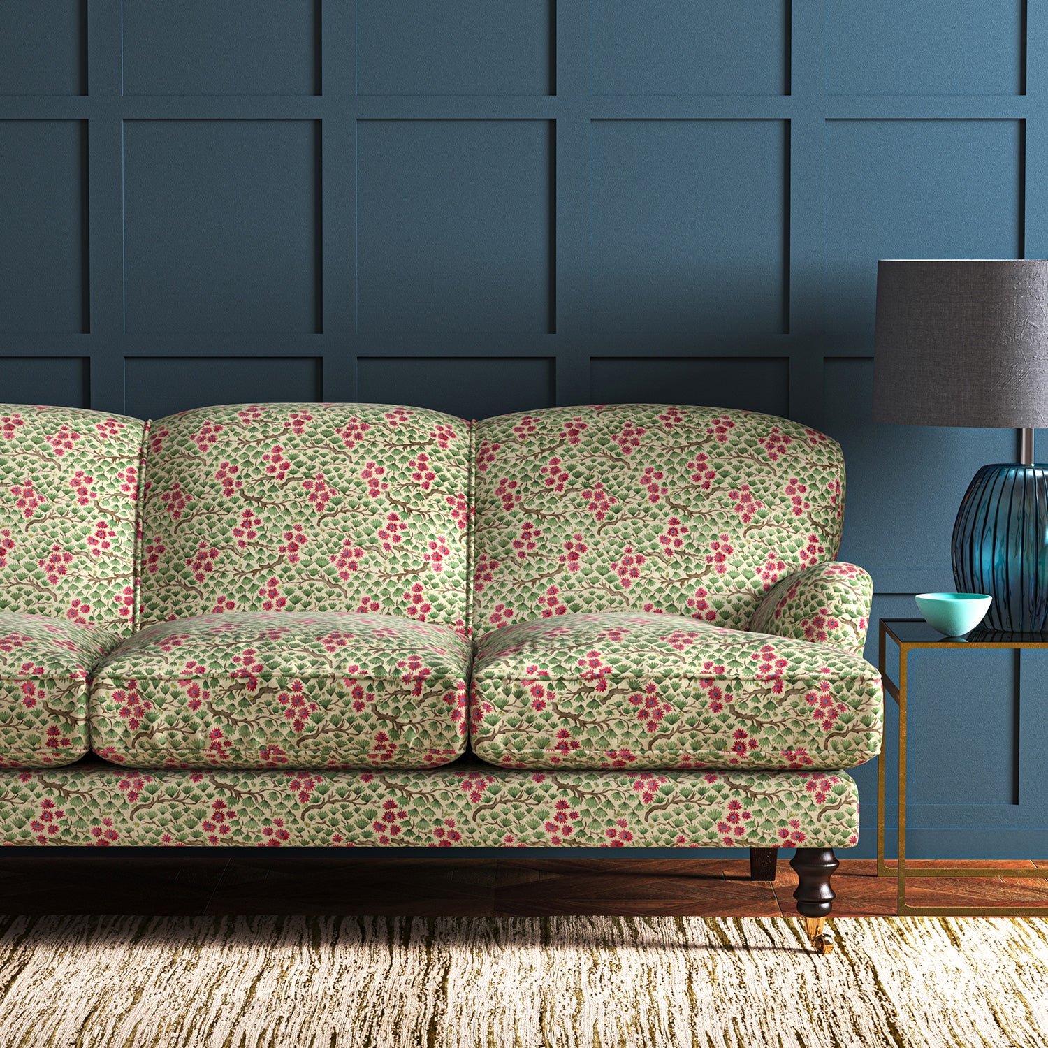 A printed velvet fabric which captures the beauty of the forest floor: leaves, brand and flowers abound in pink, green and brown on a sofa