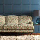 A printed velvet fabric which captures the beauty of the forest floor: leaves, brand and flowers abound in pink, green and brown on a sofa