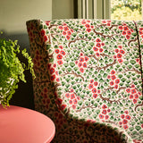 A printed velvet fabric which captures the beauty of the forest floor: leaves, brand and flowers abound in pink, green and brown on a sofa