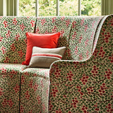 A printed velvet fabric which captures the beauty of the forest floor: leaves, brand and flowers abound in pink, green and brown on a sofa